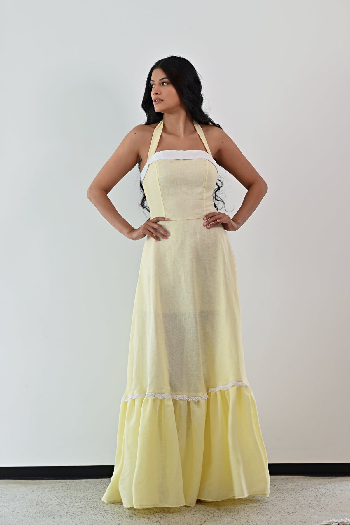 Woman wearing a light yellow dress with a white lace